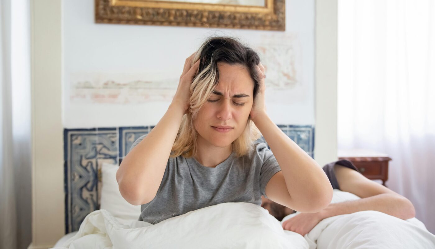 Photo by Kampus Production: https://www.pexels.com/photo/woman-in-gray-shirt-holding-her-head-while-sitting-on-the-bed-7556601/