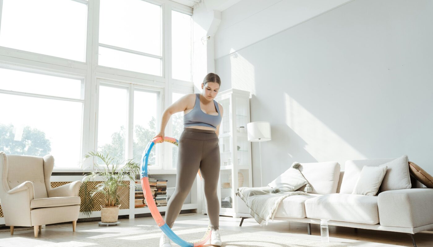 Photo by MART PRODUCTION: https://www.pexels.com/photo/a-woman-using-a-hula-hoop-in-the-living-room-8846459/