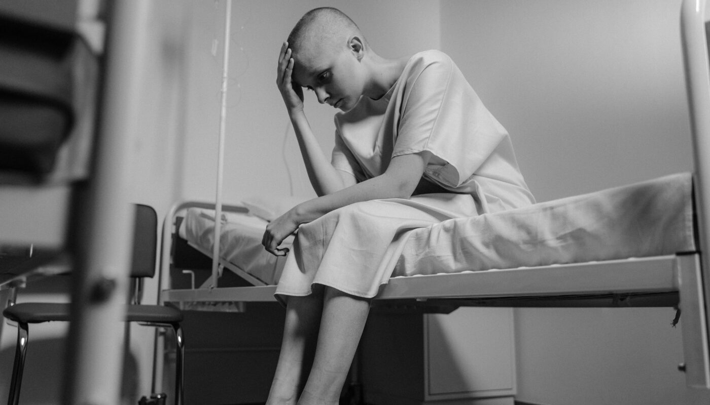Photo by Tima Miroshnichenko: https://www.pexels.com/photo/grayscale-photo-of-a-hairless-girl-sitting-in-the-hospital-ward-6010877/