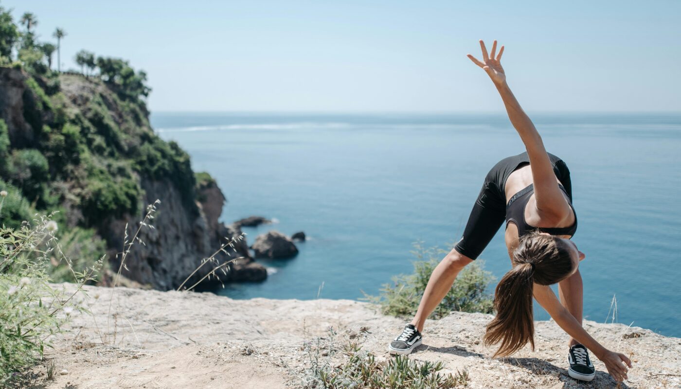 Photo by Pavel Danilyuk: https://www.pexels.com/photo/woman-in-black-sports-bra-doing-bending-and-stretching-exercise-on-mountain-cliff-8861031/