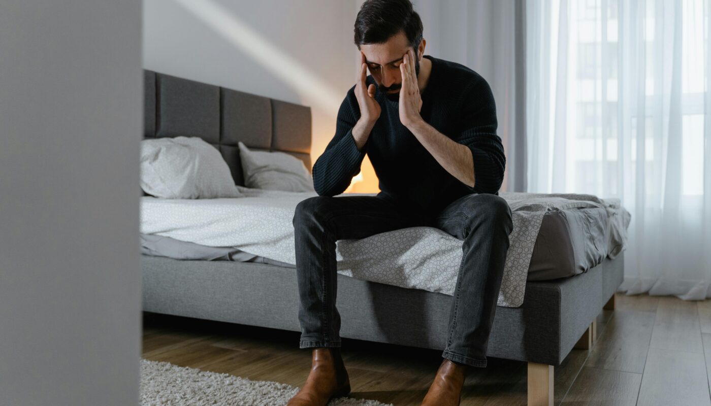 Photo by MART PRODUCTION: https://www.pexels.com/photo/a-man-in-black-sweater-sitting-on-the-bed-7699424/