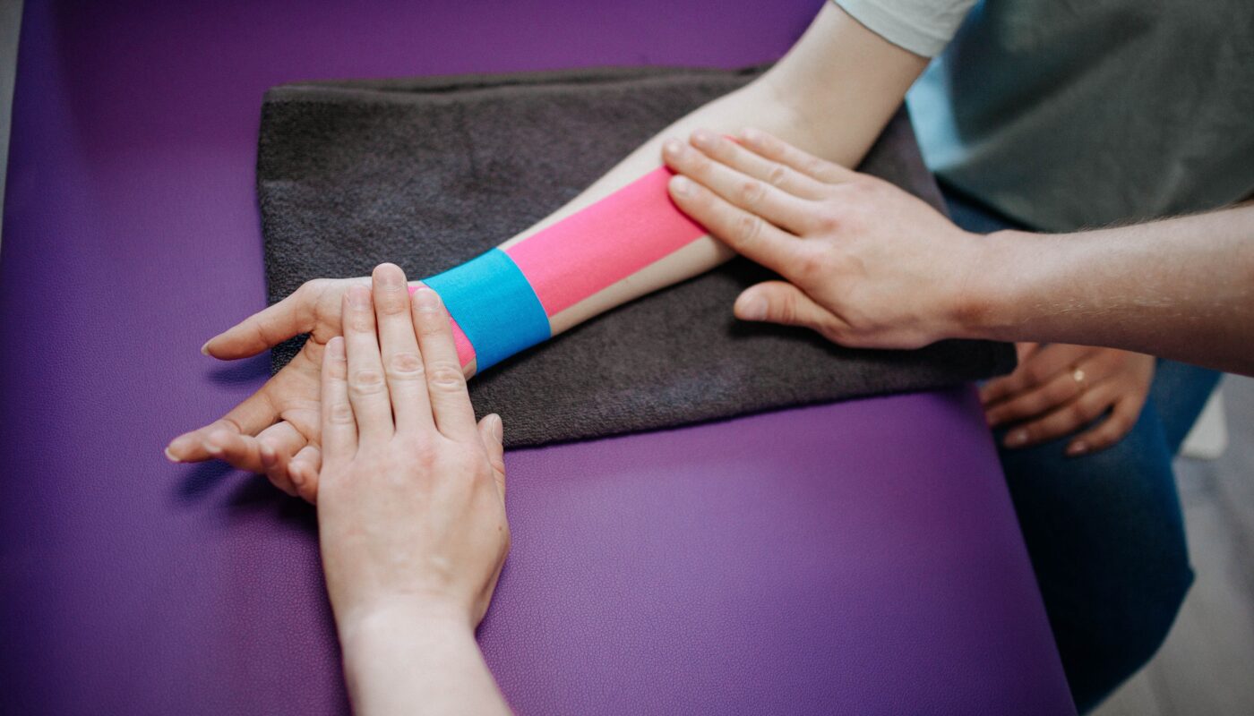 Photo by Danik Prihodko: https://www.pexels.com/photo/a-person-putting-kinesio-tape-on-another-person-8219160/