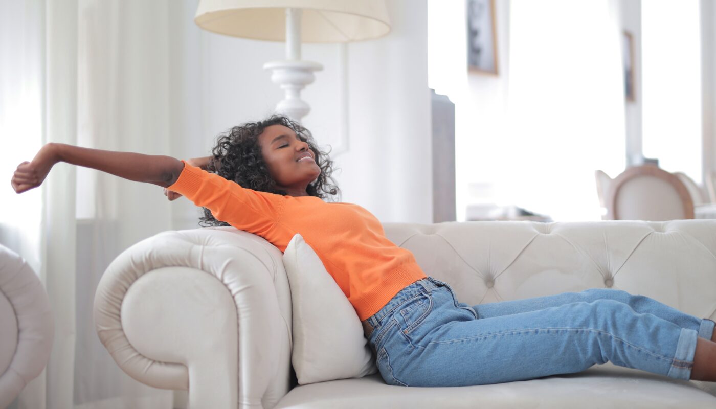 Photo by Andrea Piacquadio: https://www.pexels.com/photo/woman-in-orange-t-shirt-and-blue-denim-jeans-lying-on-white-sofa-3960141/