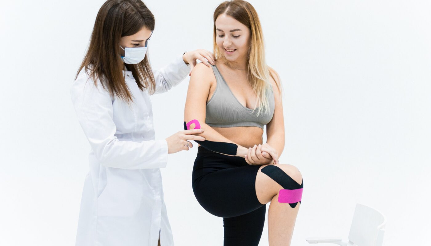 Photo by Maksim Goncharenok: https://www.pexels.com/photo/a-woman-getting-plastered-with-kinesio-tapes-by-another-woman-6094057/